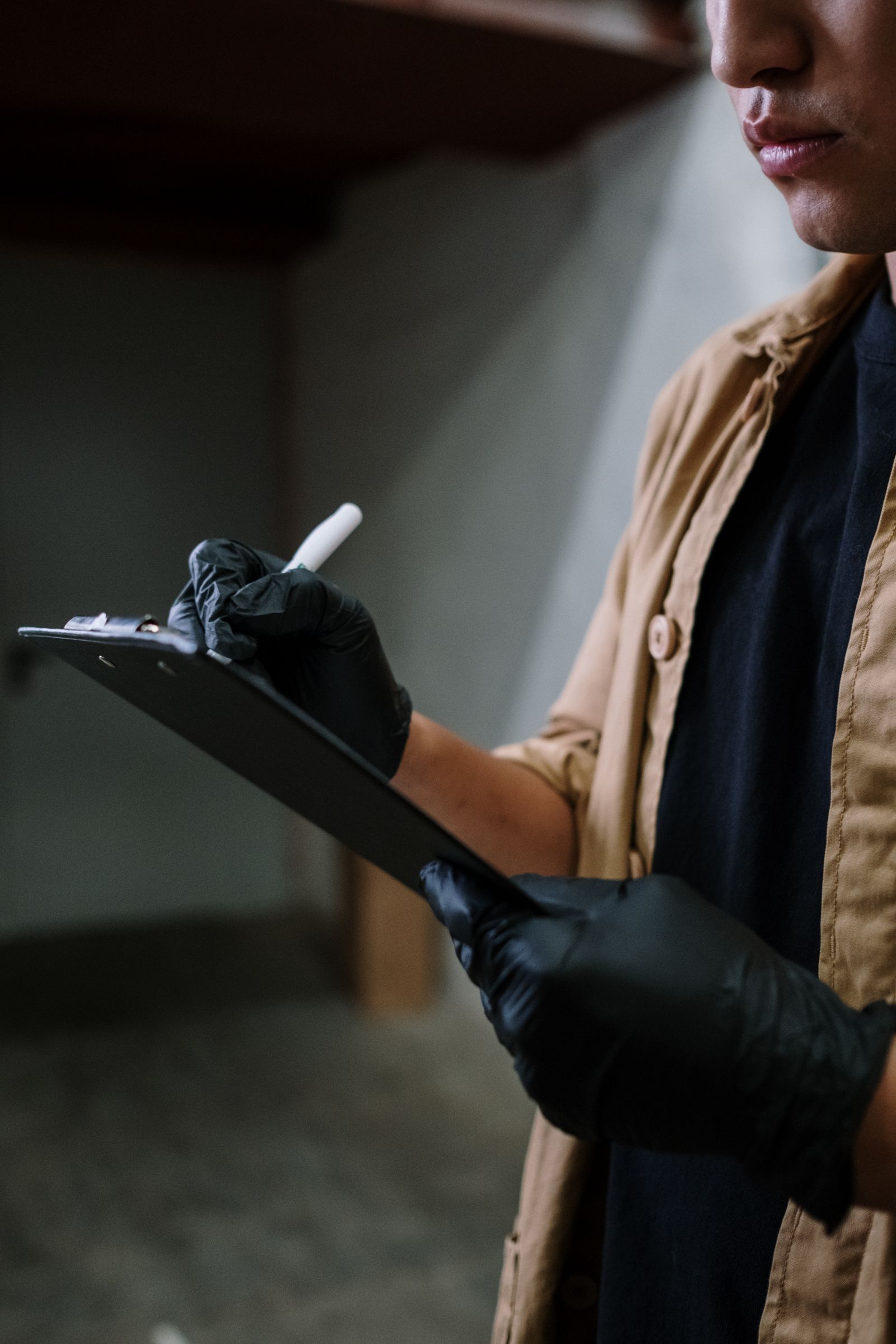 A gloved hand ticking off items on a clipboard checklist